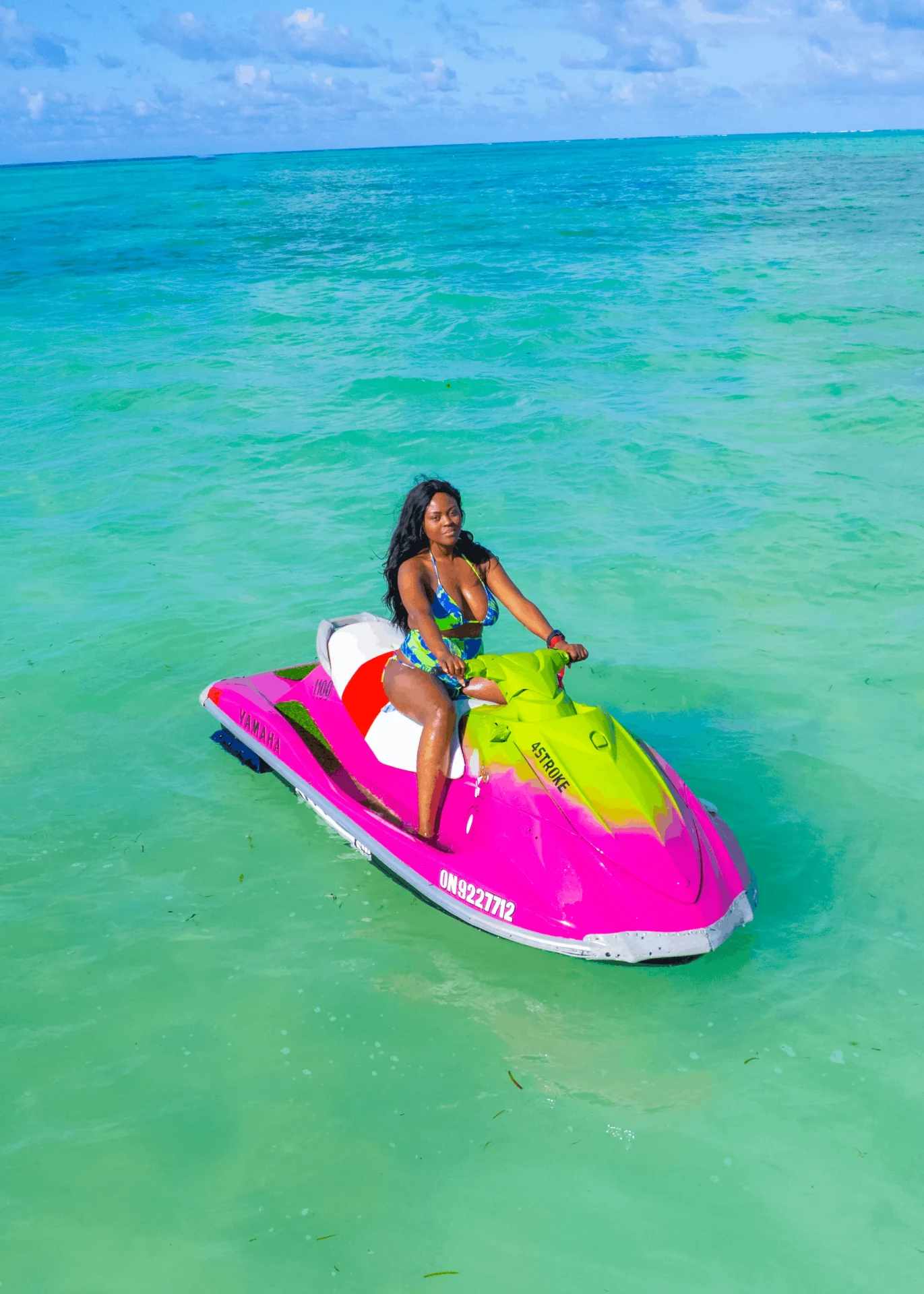 Rider on a pink jet ski with the reef on the horizon, jet ski photography in Zanzibar