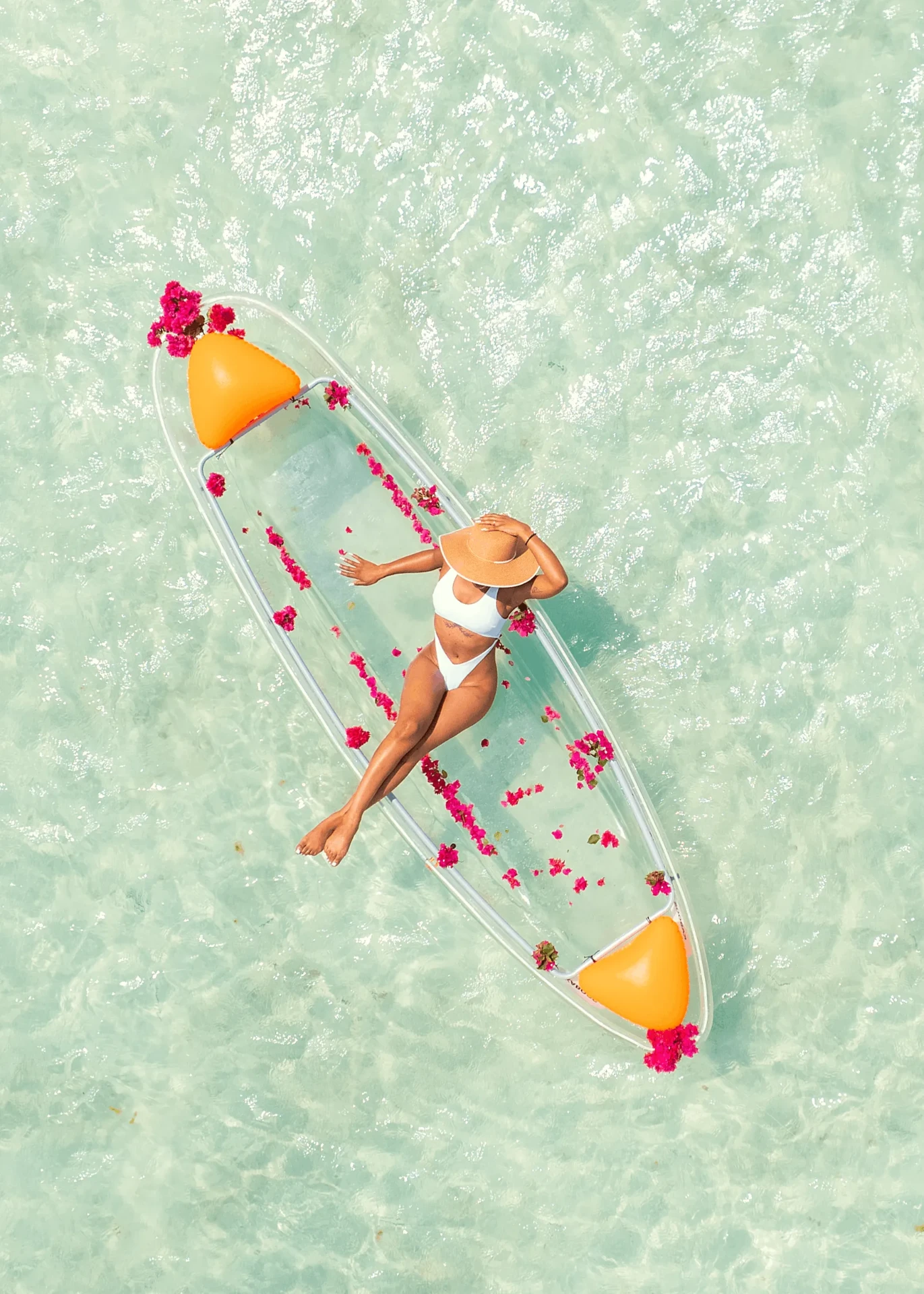 Aerial shot relaxing under a straw hat in a clear kayak, kayak photography in Zanzibar