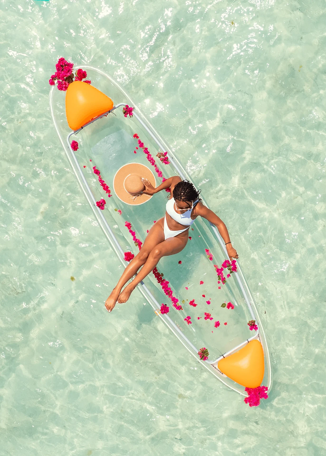 Aerial shot with flower petals lining a transparent kayak, kayak photography in Zanzibar