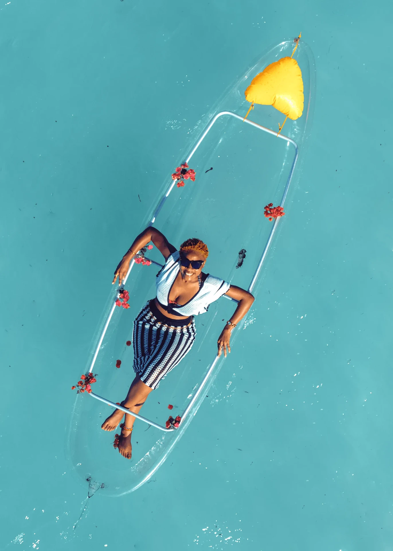 Overhead drone shot of a transparent kayak on deep turquoise water, kayak photography in Zanzibar