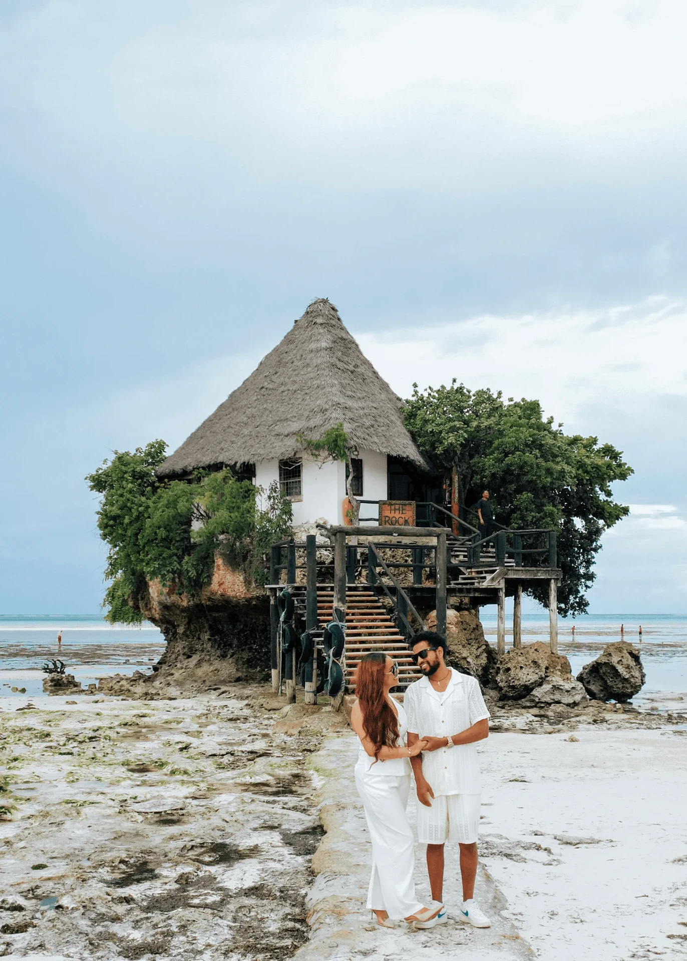 Laughing together at low tide by The Rock, couple photoshoot in Zanzibar