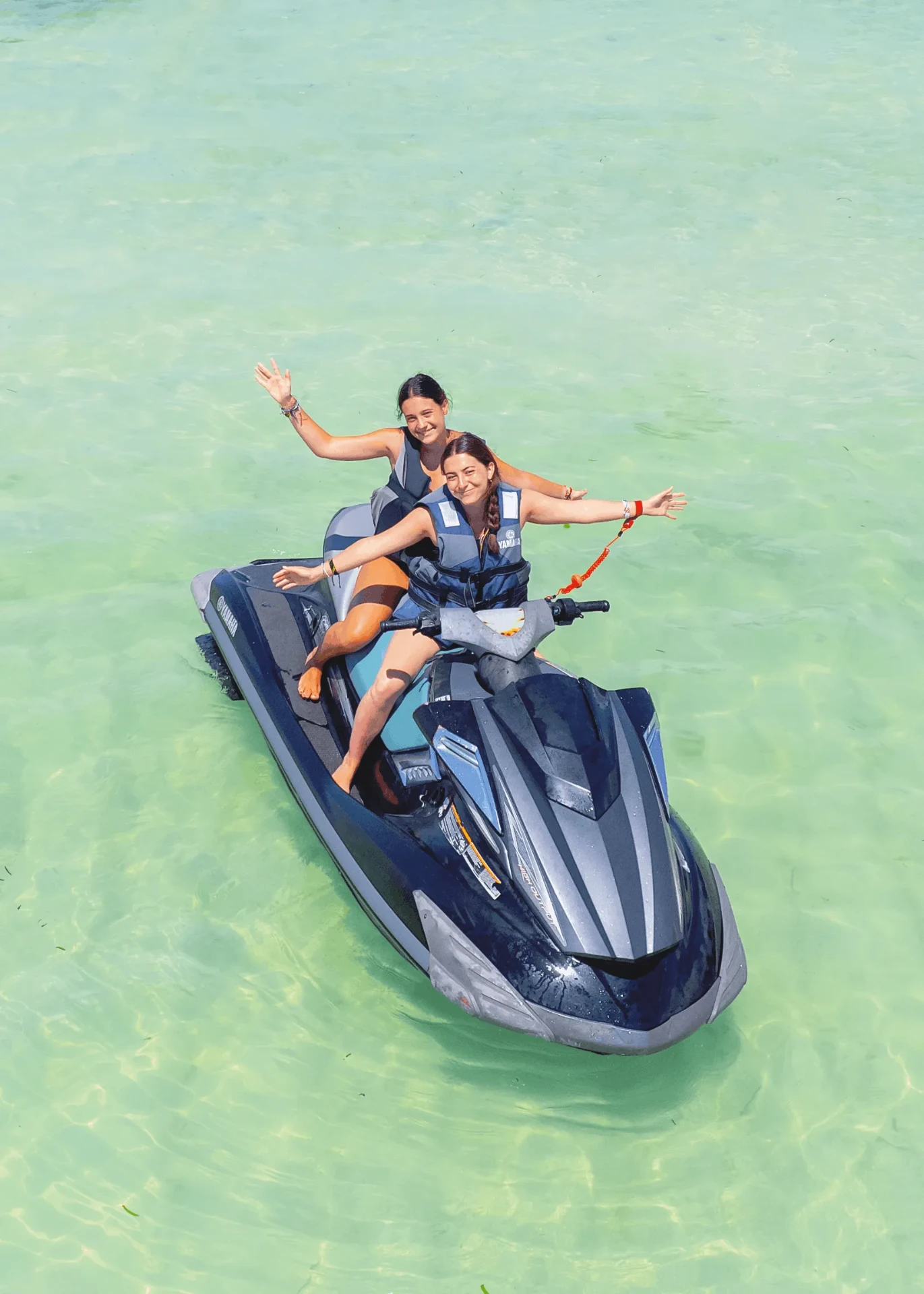 Two friends on a black jet ski in clear water, jet ski photography in Zanzibar