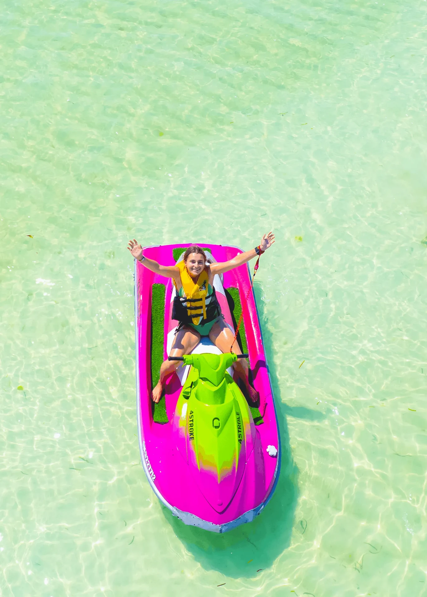 Aerial shot with arms outstretched on a pink jet ski, jet ski photography in Zanzibar