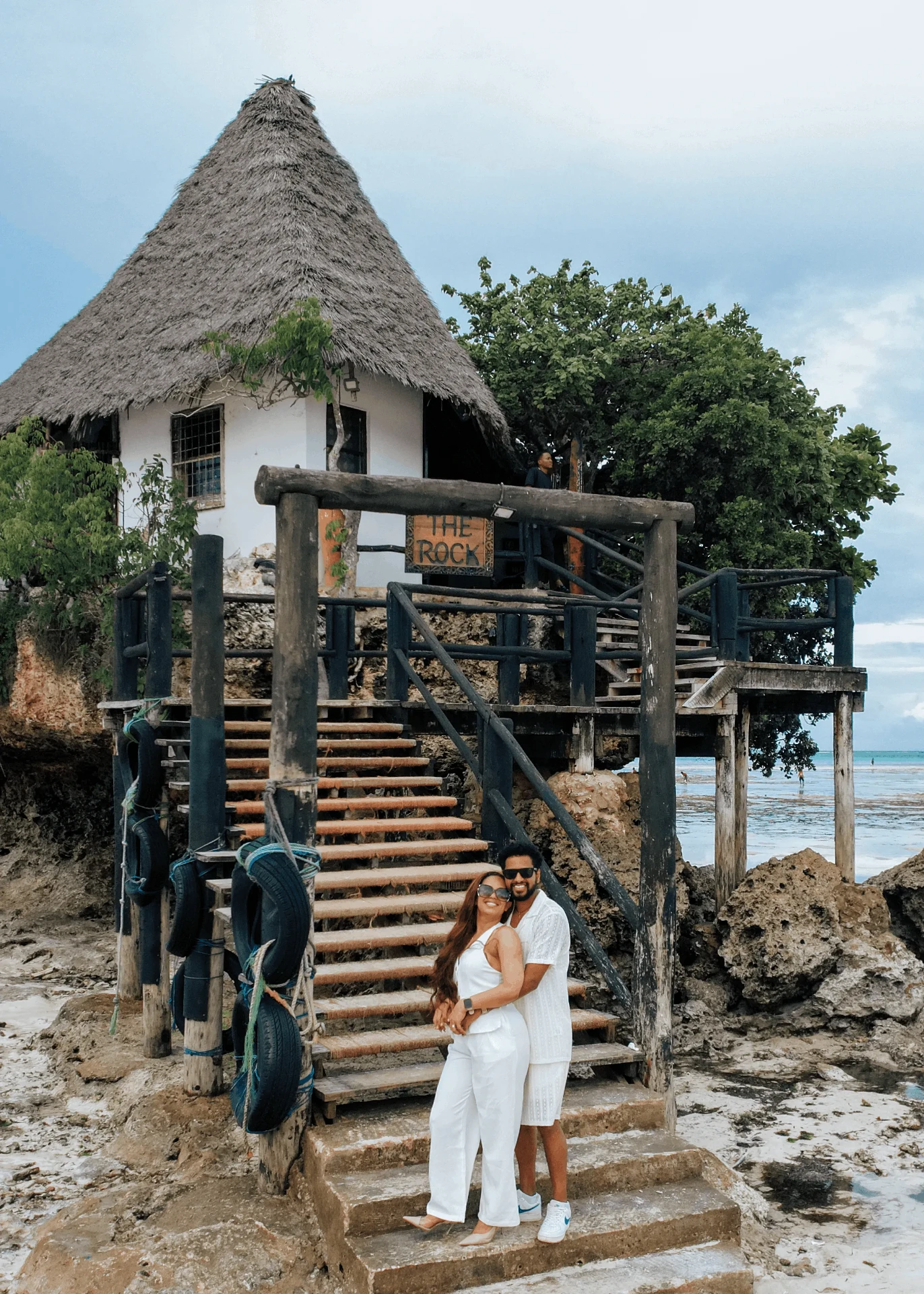 On the wooden stairs of The Rock restaurant, couple photoshoot in Zanzibar
