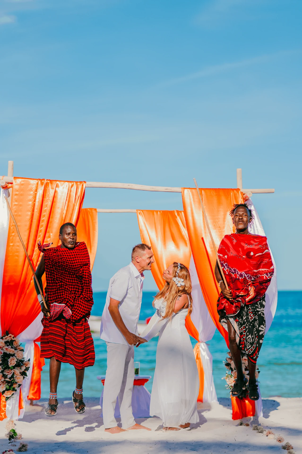 Beach ceremony under an orange draped arch, wedding photography in Zanzibar