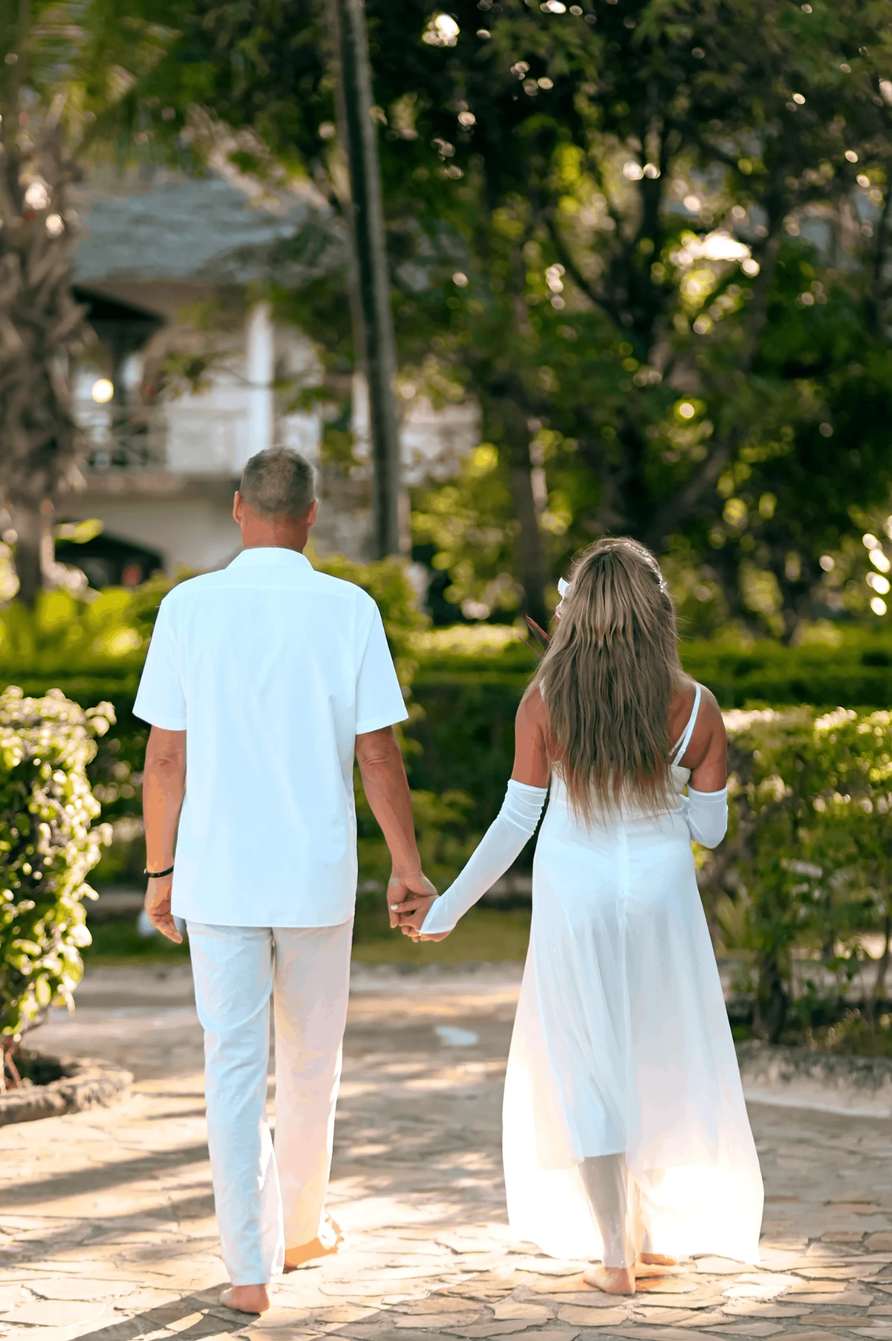 Newlyweds walking hand in hand through the gardens, wedding photography in Zanzibar